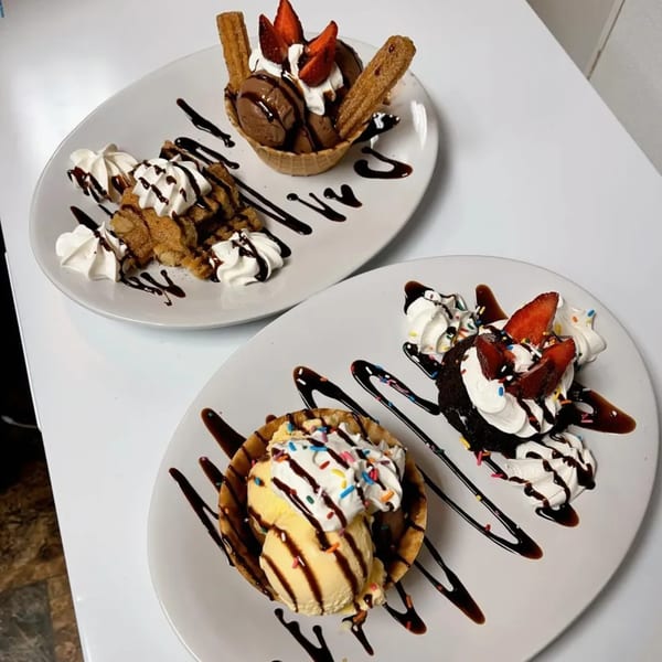 Three dessert plates featuring churros, ice cream, whipped cream, chocolate drizzle, strawberries, and sprinkles.